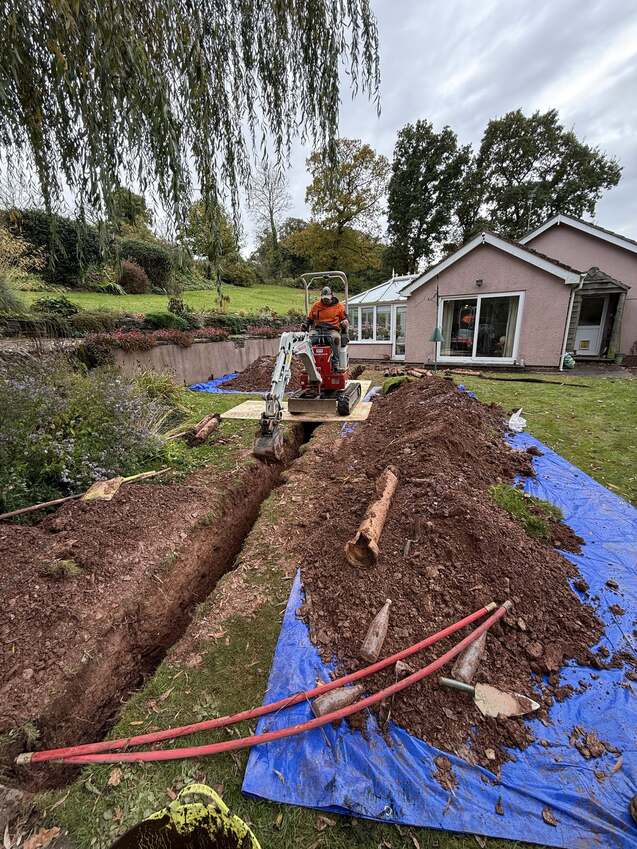 Mini excavator digging a trench for a drainage repair